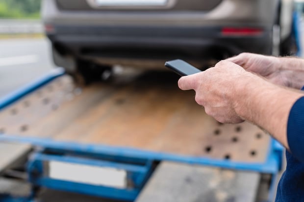 Technician using smartphone for trailer inspection