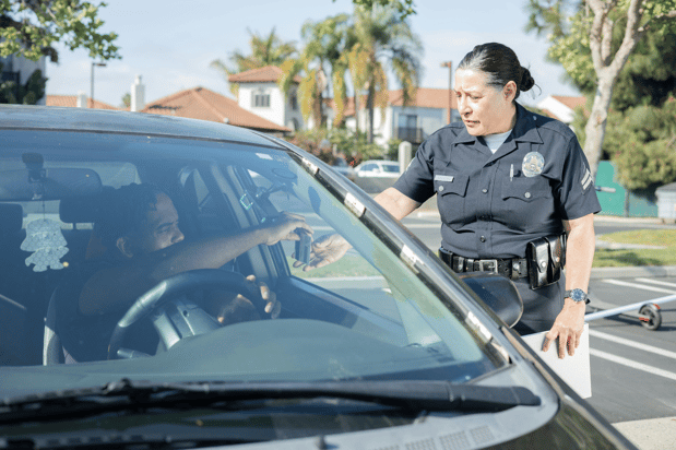 Police officer standing at a car window speaking with a driver during a traffic stop