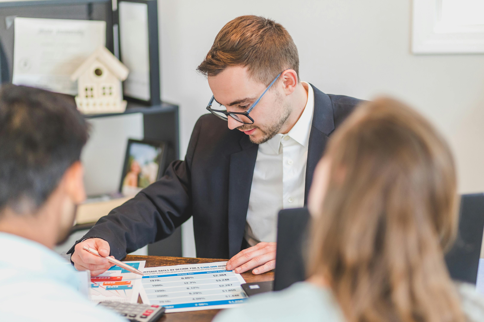 A man explaining charts and data to others during a meeting.