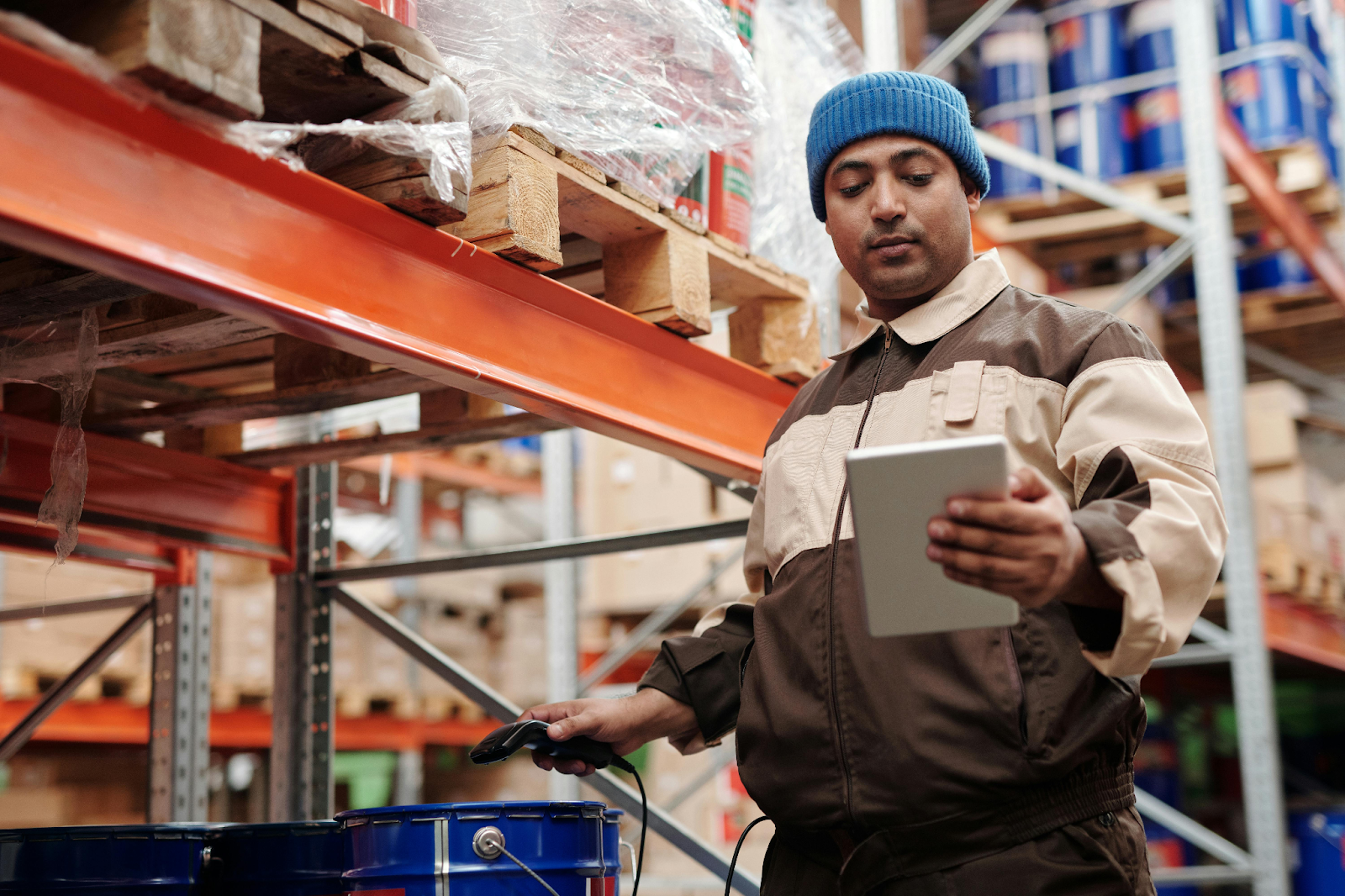Warehouse worker using tablet and digital app for offline inventory data collection and barcode scanning.